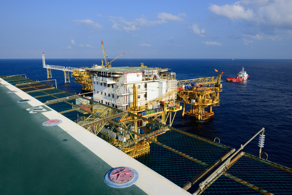 The big offshore oil rig platform and supply boat